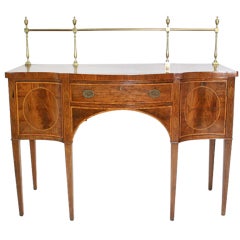 A George III faded mahogany small-scale serpentine sideboard.