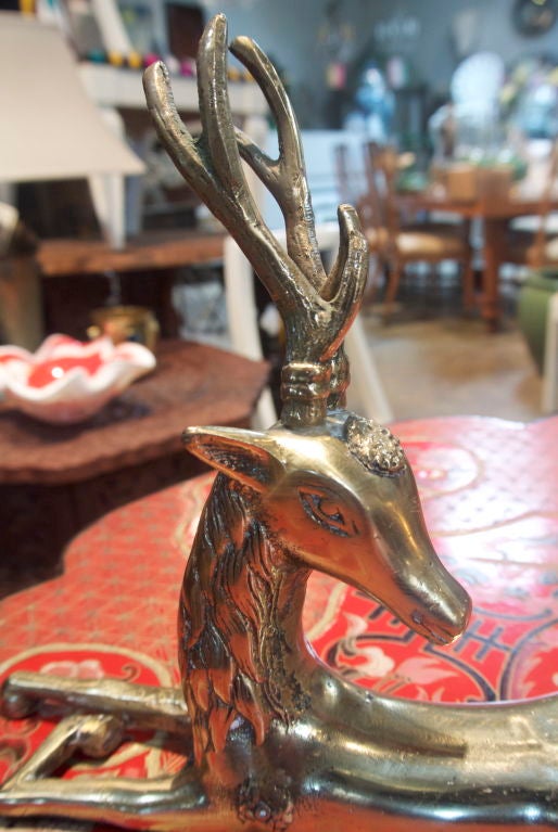Vintage pair of brass deer with decorative carvings.