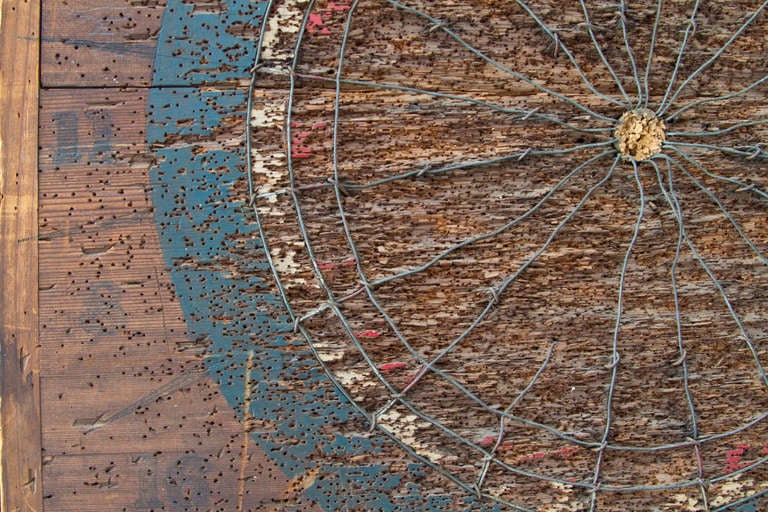 This classic dart board shows the ravages of many expert darts throwers.  The surface is ravaged, but stable.  The wires are bent, but artful.  The polychrome is faded, but resonant.  In all this board bespeaks a colorful and vibrant past.