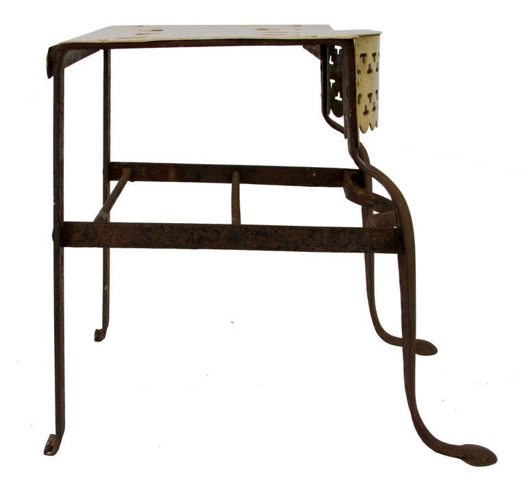 Strikingly shaped iron and brass footman with graceful shape and beautiful detail.  The front apron features delicate cutouts while the top has six beautifully rendered heart forms.  Iron is oxidized to an all over stable rusted surface.  Stunning.