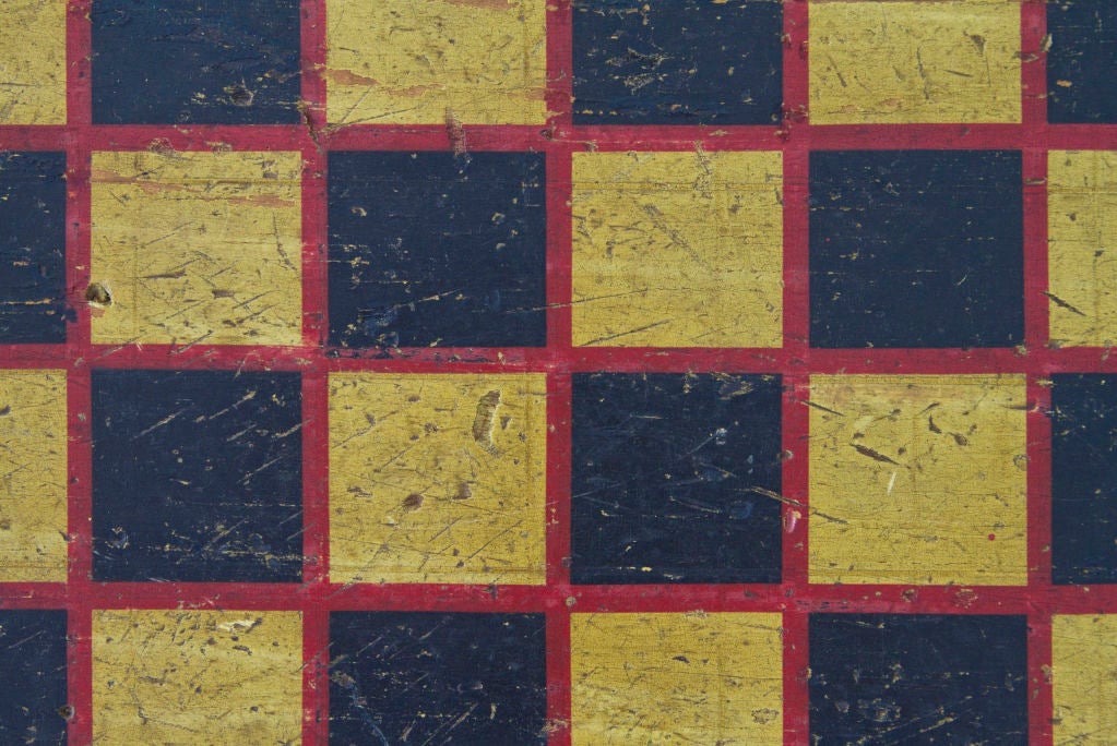 The playing surface is bordered in red atop a mustard ground.  Each square is also bordered resulting in a strong graphic appearance.