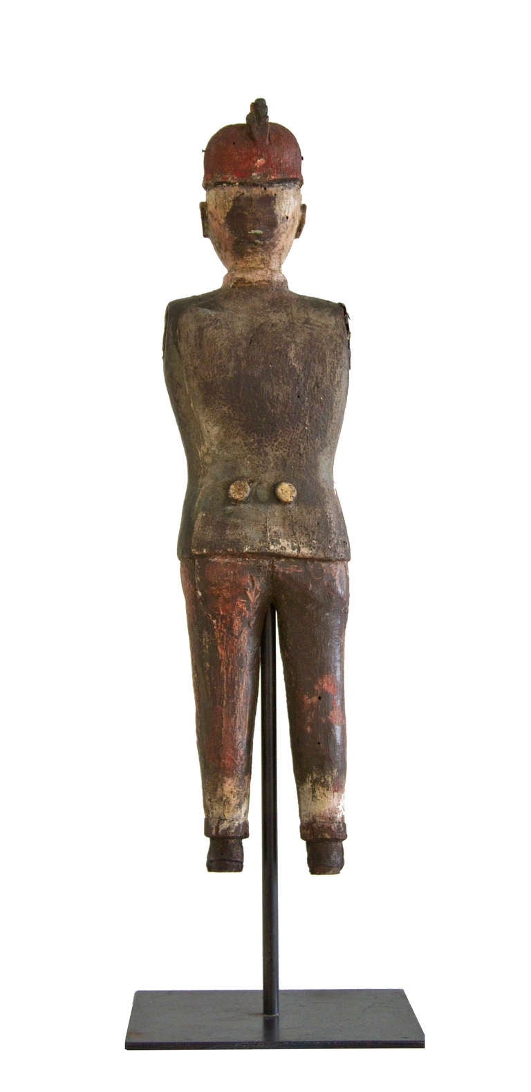 Hand carved wooden figure of a mid 19th century fireman.  The feet and paddles are long gone. Applied wooden buttons adorn both sides of his uniform.  Original painted and weathered surface with pleasing craquelure on his coat and trousers. 