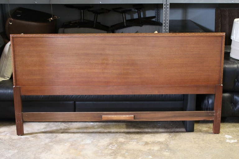 A mahogany headboard with greek key detail designed by Frank Lloyd Wright for Henredon.