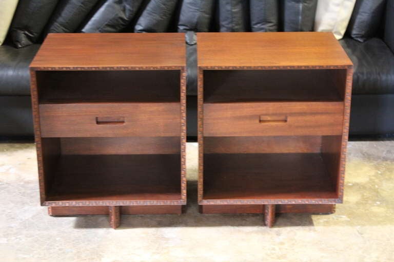 A pair of mahogany nightstands with greek key details designed by Frank Lloyd Wright for Henredon.