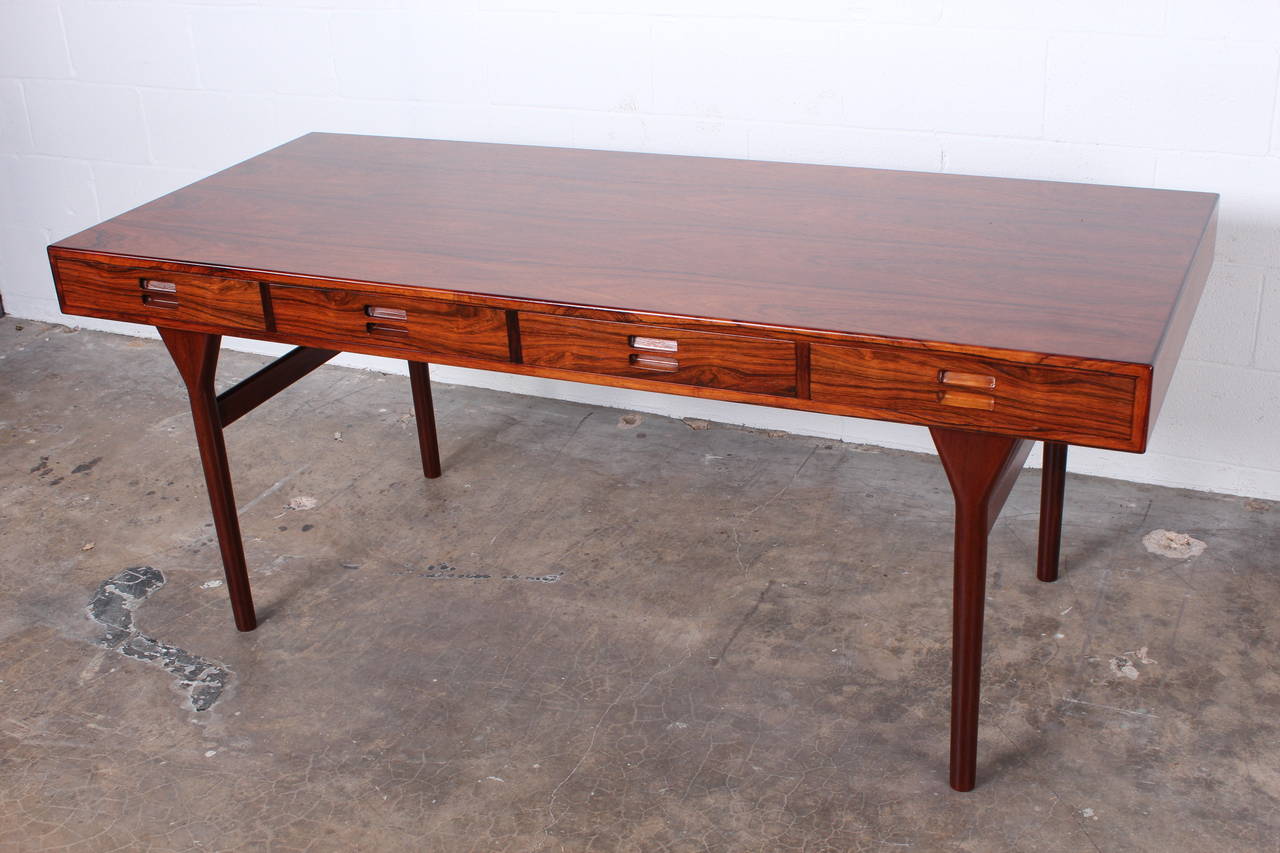 A large four-drawer pencil desk with expressive rosewood graining. Designed by Nanna Ditzel.