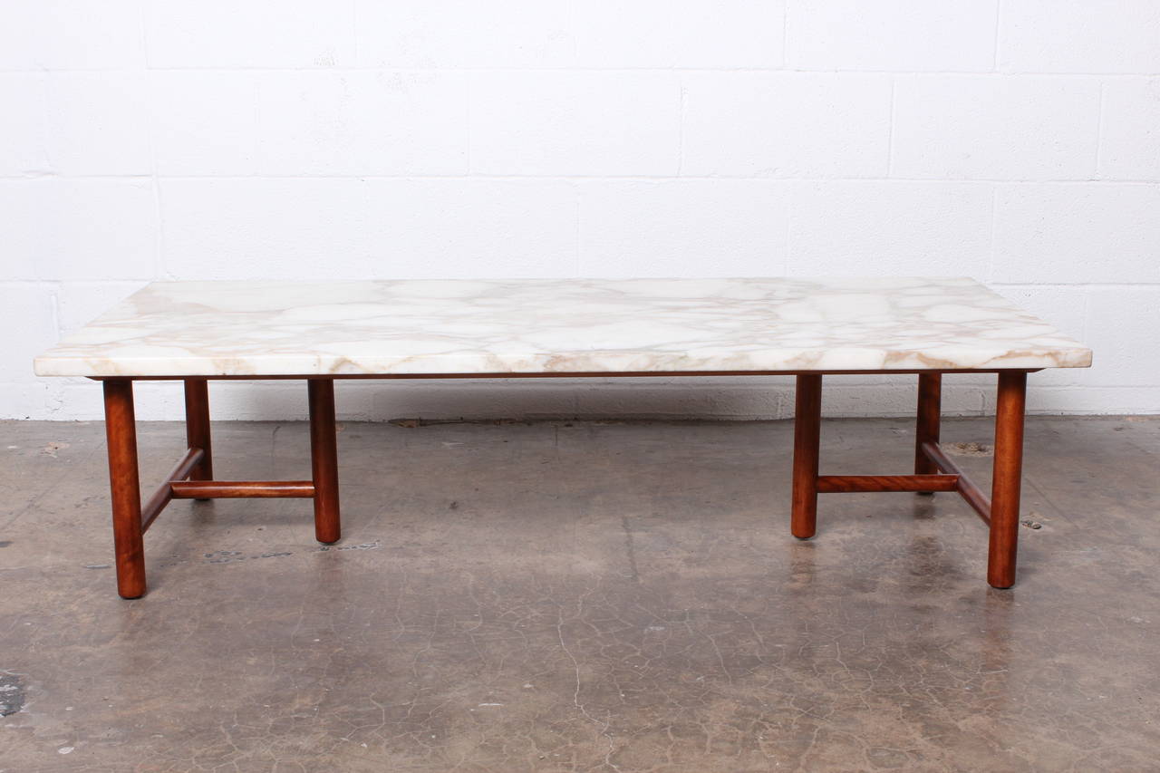 A marble-top coffee table with walnut base. Designed by T.H. Robsjohn-Gibbings for Widdicomb.
