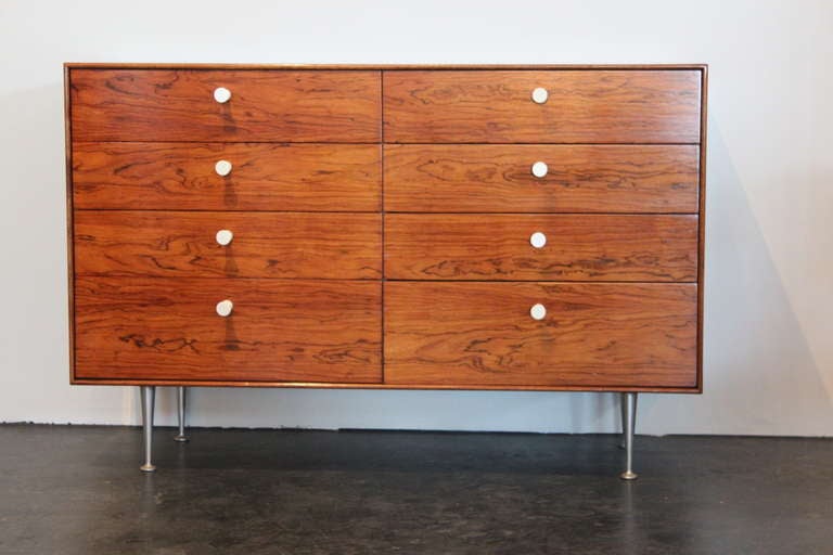 A beautiful rosewood thin edge chest of drawers with original aluminum legs and porcelain pulls. Designed by George Nelson for Herman Miller.