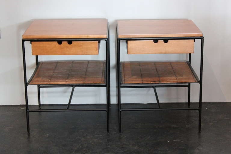 A pair of iron and maple bedside tables with bamboo shelf.