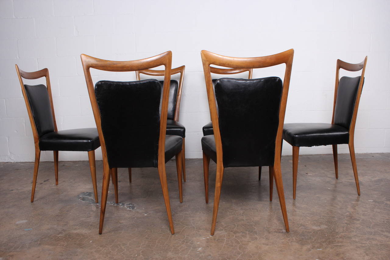 A set of six dining chairs in walnut and original black vinyl designed by Melchiorre Bega.