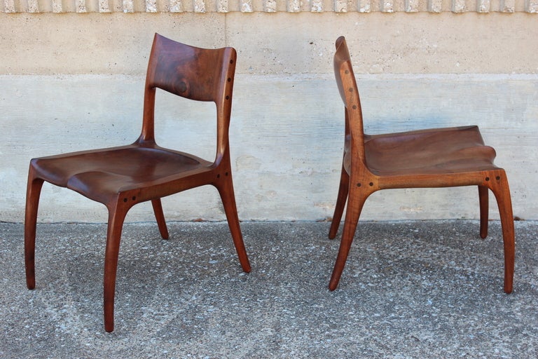 A beautifully crafted pair of solid walnut side chairs by California craftsman Rick Pohlers. These chairs were commissioned by the original owners who had several pieces of Pohlers work spanning two decades. 