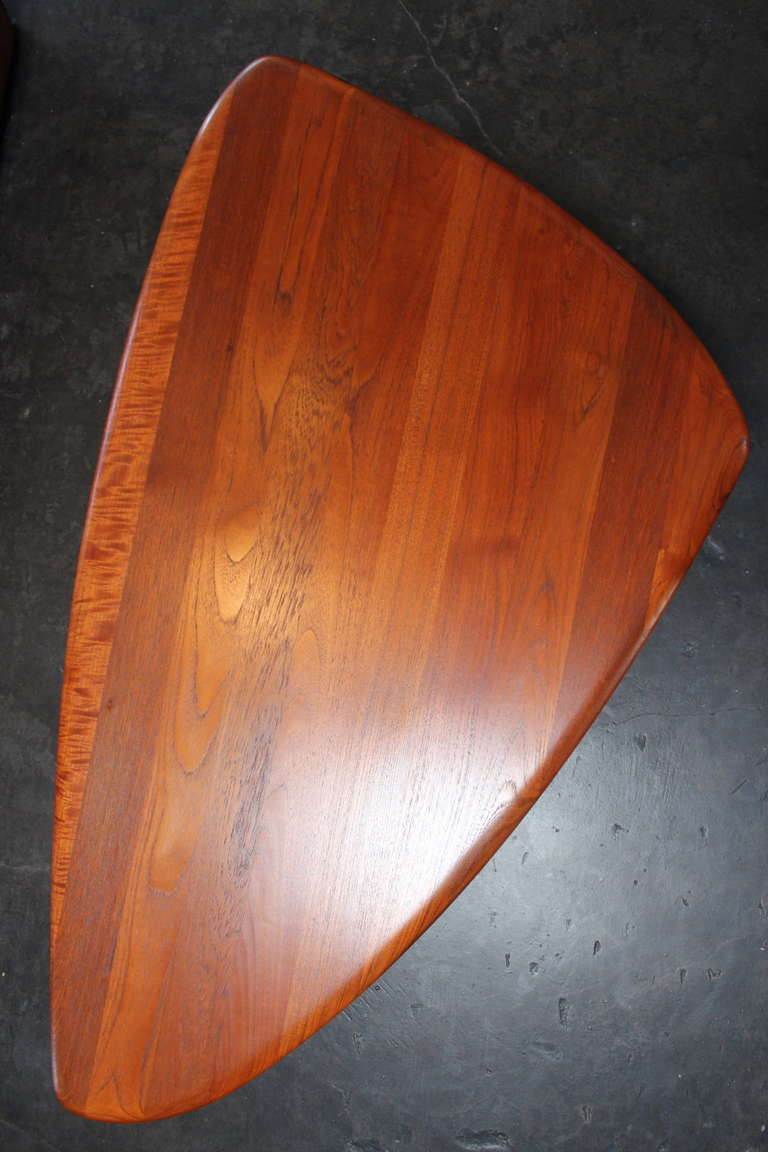 A large, solid teak danish coffee table on three tapered legs. Designed by Johannes Aasbjerg.