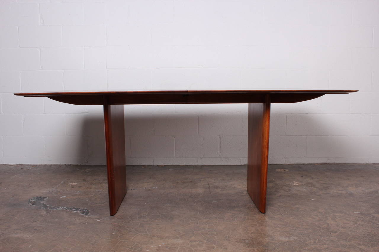 A walnut fin-legged dining table with two leaves. Designed by T.H. Robsjohn-Gibbings for Widdicomb.