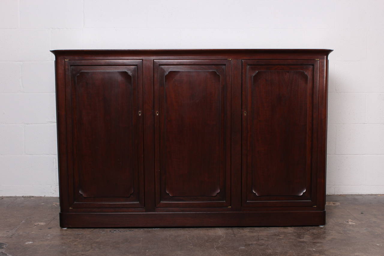 A well crafted, sculpted mahogany cabinet with three locking doors. Designed by Edward Wormley for Dunbar.