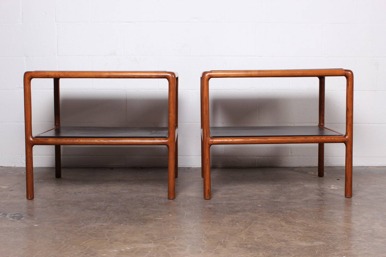 A pair of oak framed lamp tables with insert dark brown leather tops by Ward Bennett.