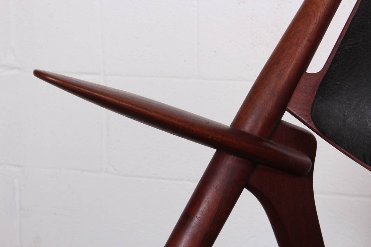 An early Wegner CH28 sawback lounge chair for Carl Hansen & Sons. Teak has nice patine and original leather is worn.