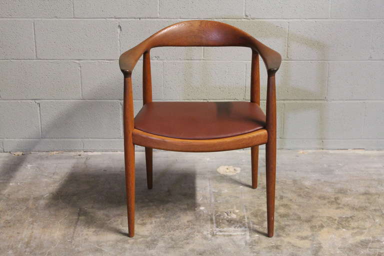 A classic, teak chair with leather seat. Designed by Hans Wegner and made by Johannes Hansen, cabinetmaker.