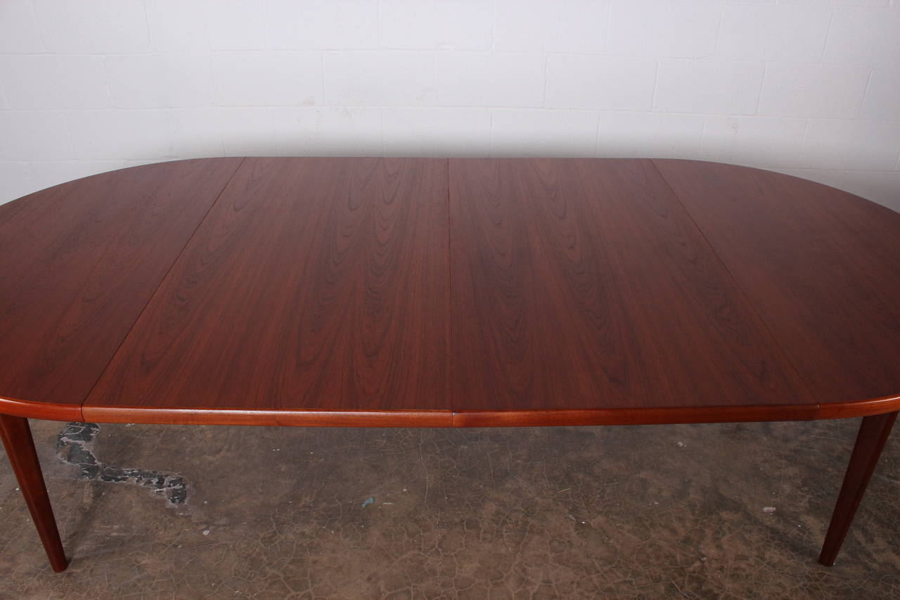 A teak dining table with eight teak and Danish cord chairs by Peter Hvidt.