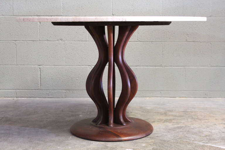 A sculptural walnut table with travertine top by Brown Saltman.