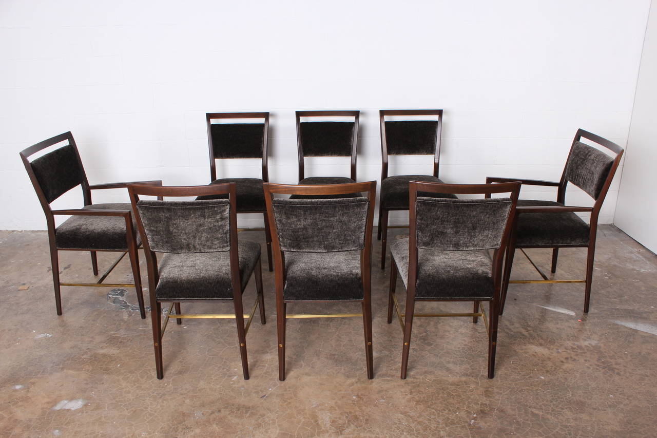 A beautifully restored set of eight mahogany dining chairs with brass stretchers. Designed by Paul McCobb.