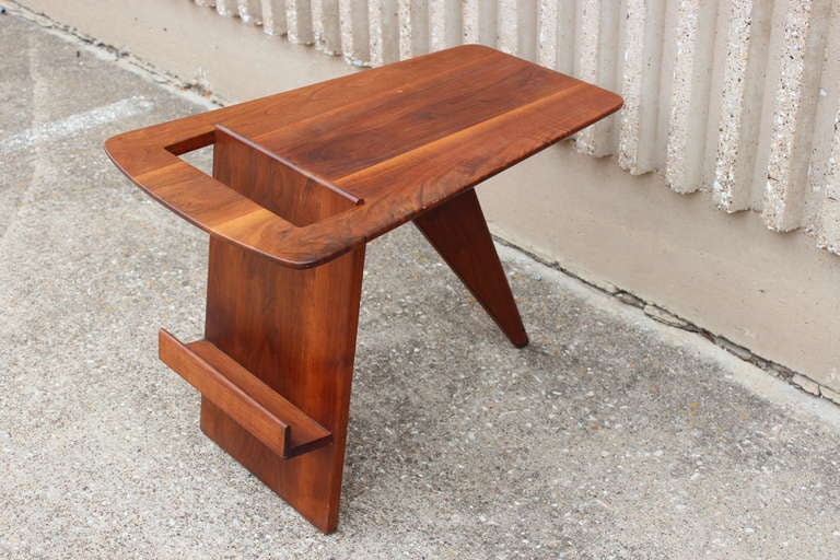 A solid walnut side/magazine table designed by Jens Risom.