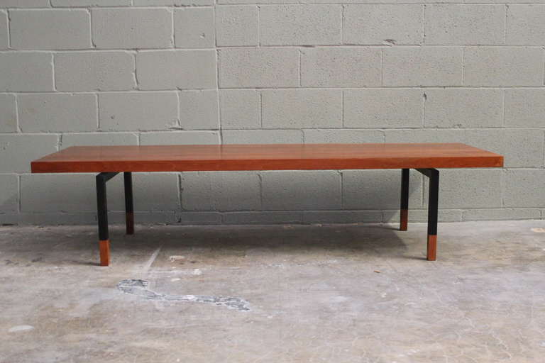 A solid teak coffee table with metal legs and teak tips. Designed by Johannes Aasbjerg.