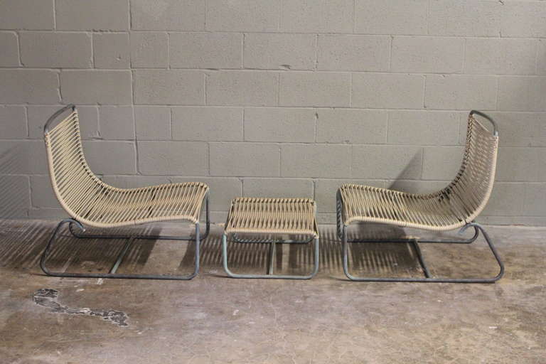A pair of outdoor low lounge chairs and matching ottoman with original plastic cording. Designed by Walter Lamb.