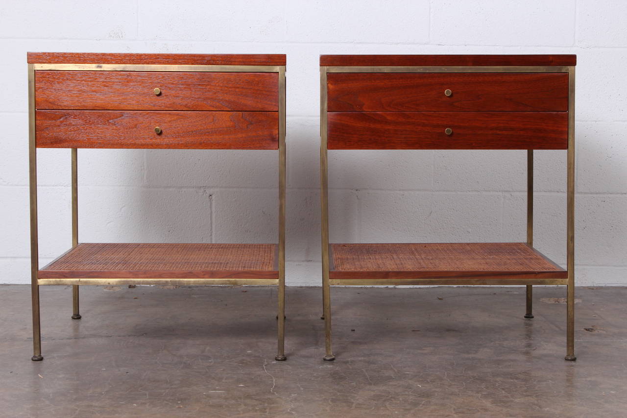 A pair of brass and mahogany nightstands with cane shelves. Designed by Paul McCobb for Calvin.