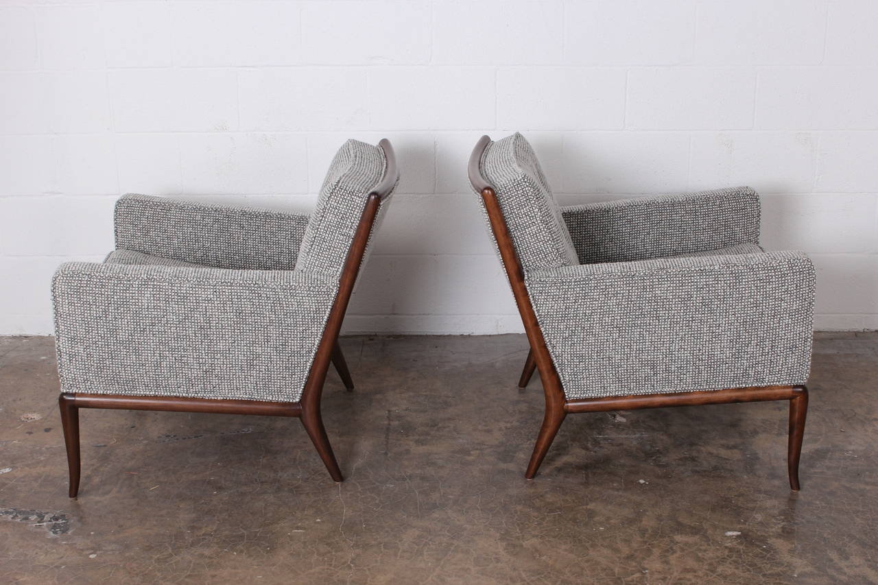 A pair of walnut framed lounge chairs designed by T.H. Robsjohn-Gibbings for Widdicomb. Fully restored and upholstered in Maharam pebble wool fabric.