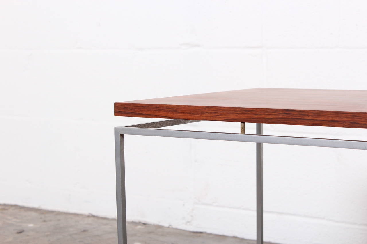 A set of three rosewood and steel nesting tables designed by Knud Joos for Jason.