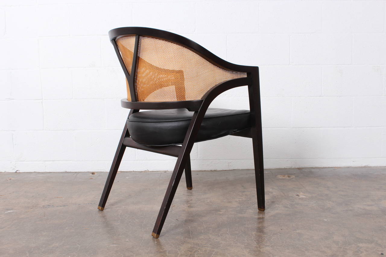 A Classic mahogany wishbone chair with cane back, brass feet and original leather upholstery.