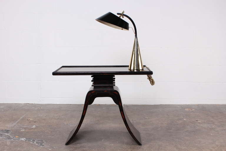 A very stylish brass desk lamp with adjustable shade.