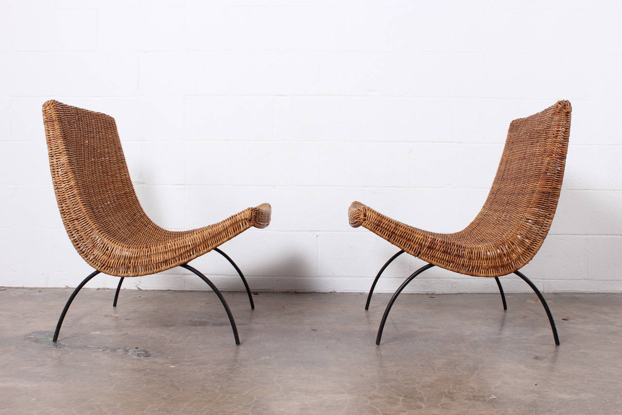 A pair of rattan and iron lounge chairs attributed to Milo Baughman.