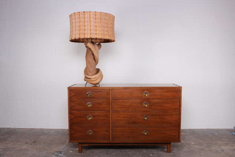 A large twisted wood lamp with solid brass feet and handmade shade.