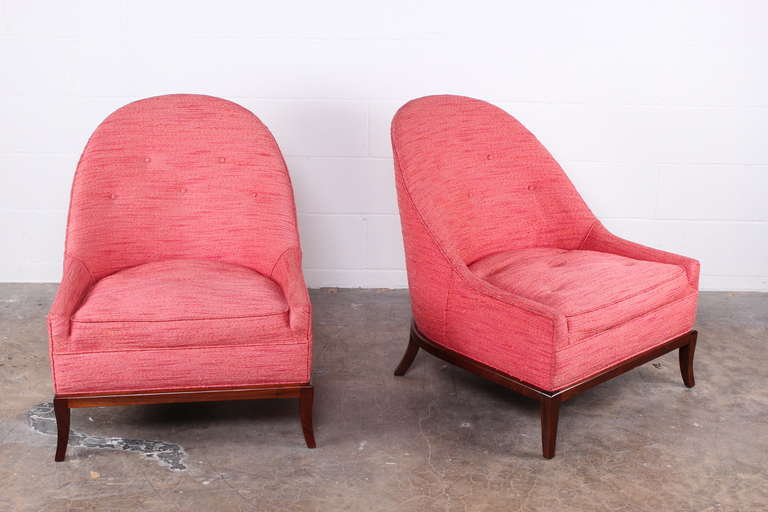 A rare pair of lounge chairs with walnut bases. Designed by T.H. Robsjohn-Gibbings for Widdicomb.