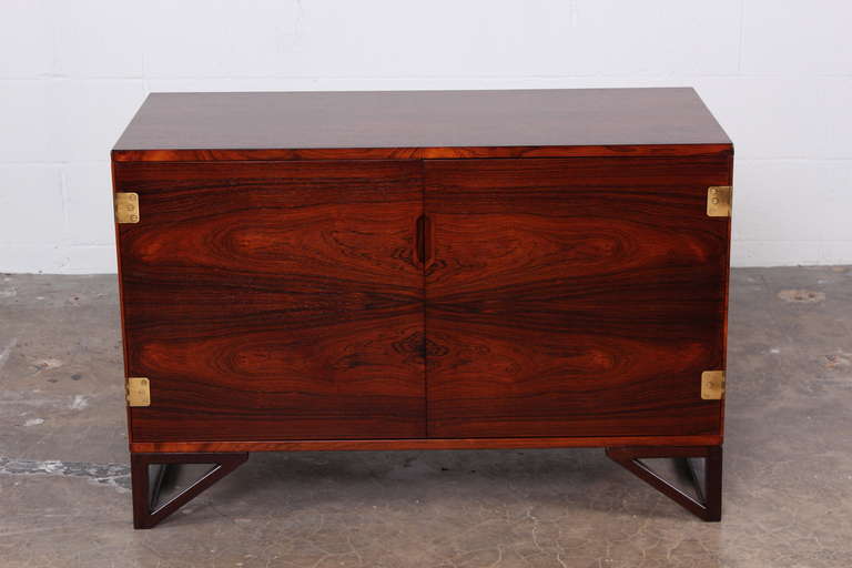 A rosewood cabinet with brass hinges and removable trays designed by Svend Langekilde.