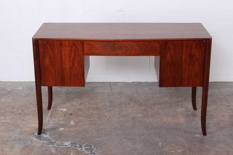 A petite walnut desk designed by T.H. Robsjohn-Gibbings for Widdicomb.