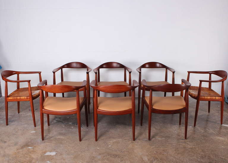 A set of eight teak round chairs designed by Hans Wegner for Johannes Hansen, cabinetmaker. Six chairs having leather seats and two having original cane seats. These can also be split up and sold as a set of six.