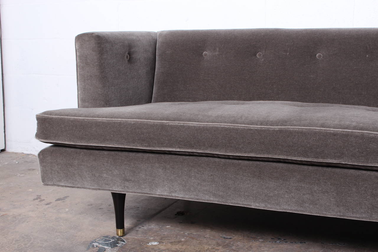 A large sofa with walnut legs and brass sabots, reupholstered in grey mohair. Designed by Edward Wormley for Dunbar.