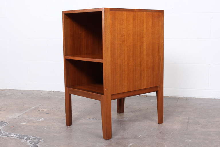 An early Dunbar bedside cabinet with open shelf. Designed by Edward Wormley.