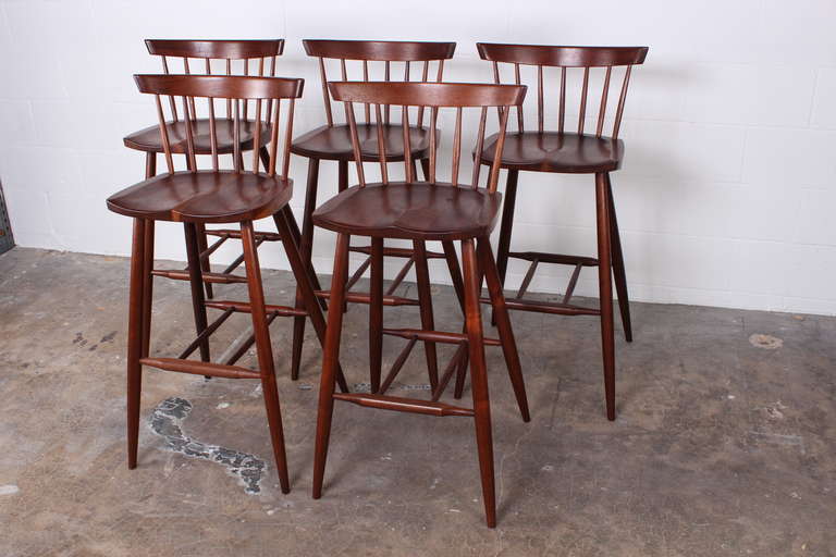 A set of five walnut barstools by George Nakashima. Signed with client name to underside of each example: [Lunna-30].