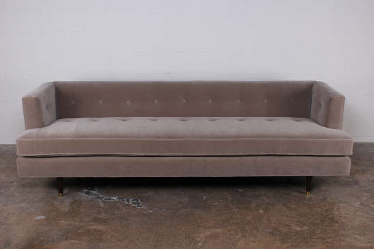 A classic Dunbar form with tapered wood legs and brass sabots. Newly upholstered in plush grey mohair. Designed by Edward Wormley. We also have a nine foot version of this sofa in stock.