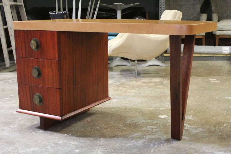 A Mahogany desk with cork top and brass hardware. Designed by Paul Frankl for Johnson Furniture.