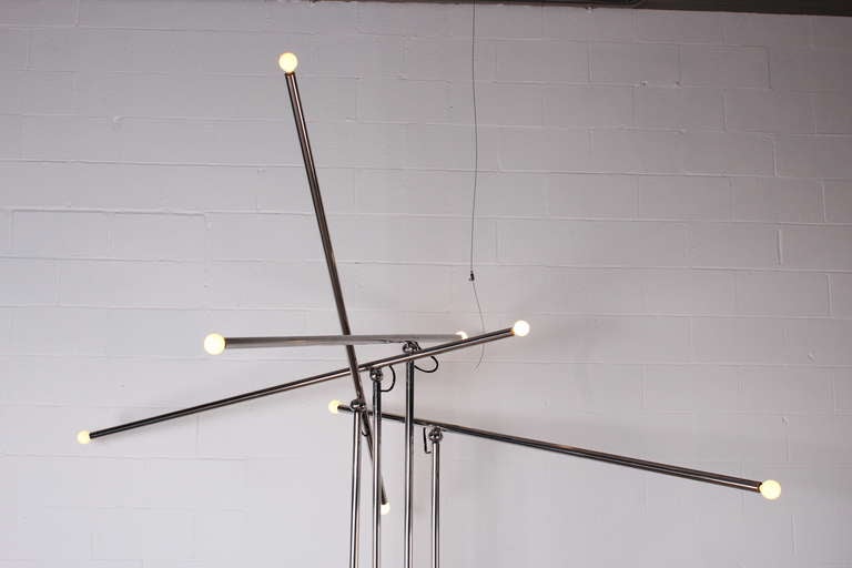 A monumental floor lamp with four articulating and swiveling arms.
