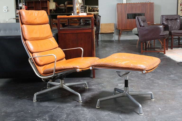 A wonderfully patinated leather high back tilt/swivel lounge chair and ottoman by Charles Eames for Herman Miller.