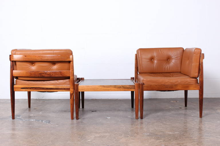 A three piece modular unit with solid rosewood frame and original leather upholstery. The table has an inset stone top. Designed by Kai Kristiansen.