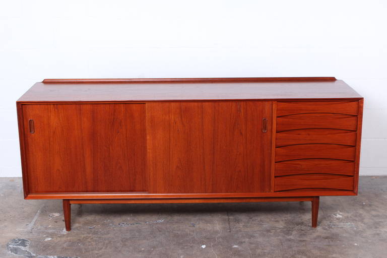 Teak credenza designed by Arne Vodder and manufactured by Sibast furniture of Denmark. Cabinet with 2 sliding reversible doors and six drawers.