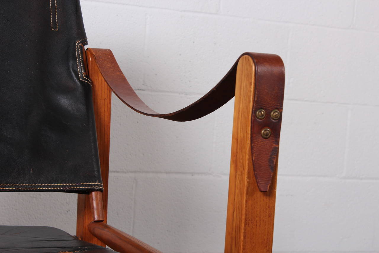 A pair of leather safari chairs with nice patina. Designed by Kaare Klint.