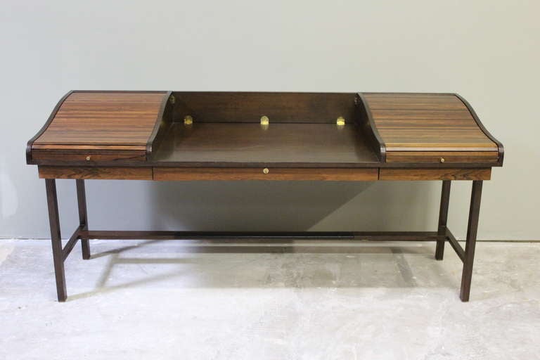 A classic and iconic Wormley design. This elegant desk features solid rosewood tambours with brass hardware and a walnut base. Designed by Edward Wormley for Dunbar.