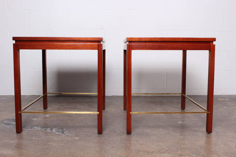 A pair of large mahogany and walnut tables with brass stretchers. Designed by Edward Wormley for Dunbar.