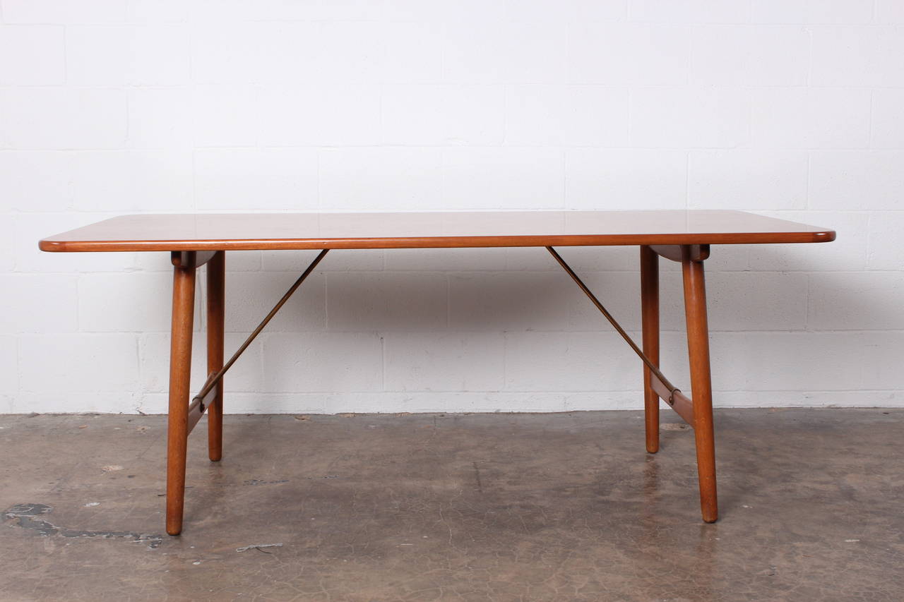 An Oak table with brass stretchers designed by Børge Mogensen.